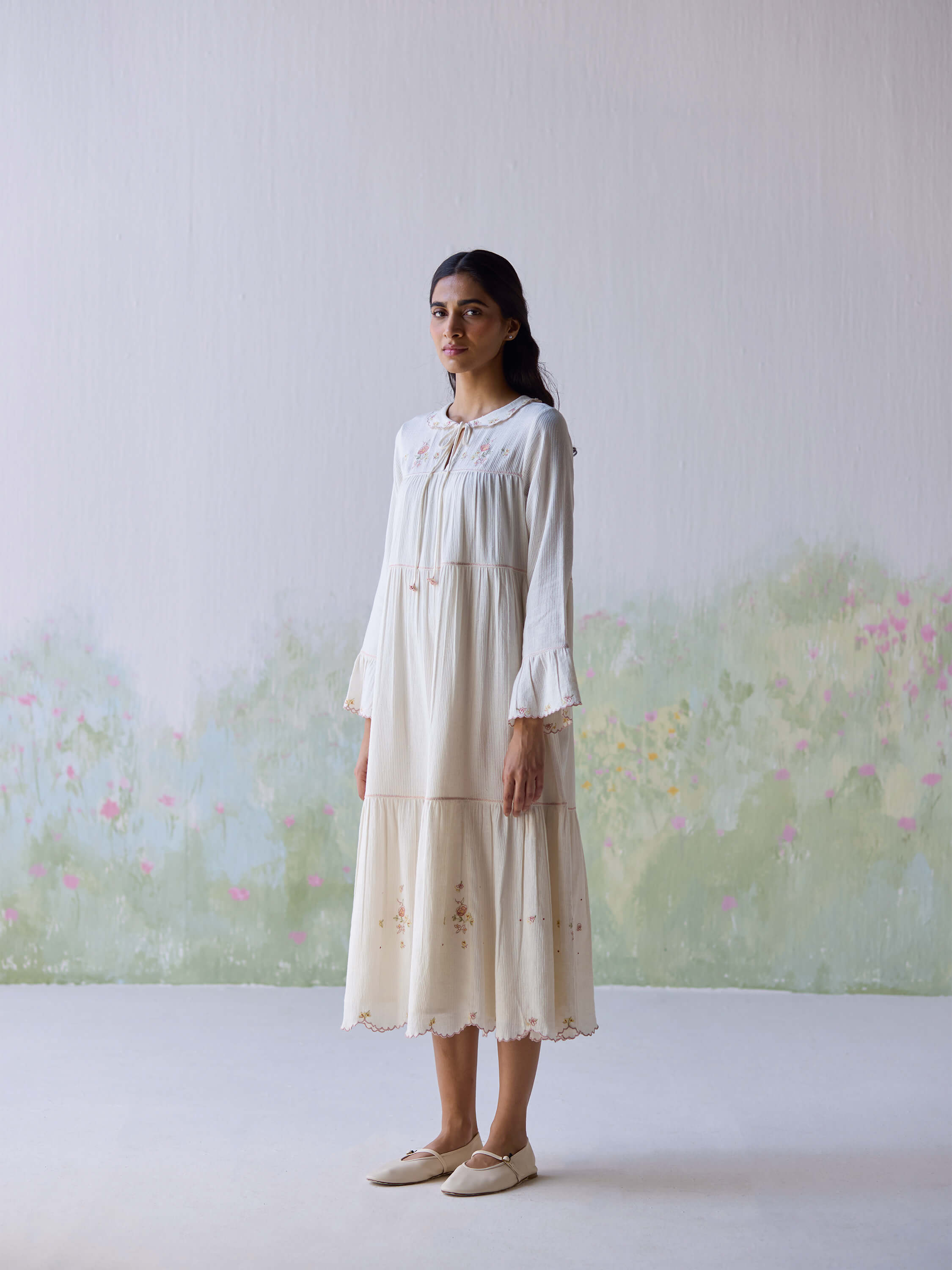 Elegant woman wearing Adagio Tier Midi Dress in soft pastel colors.