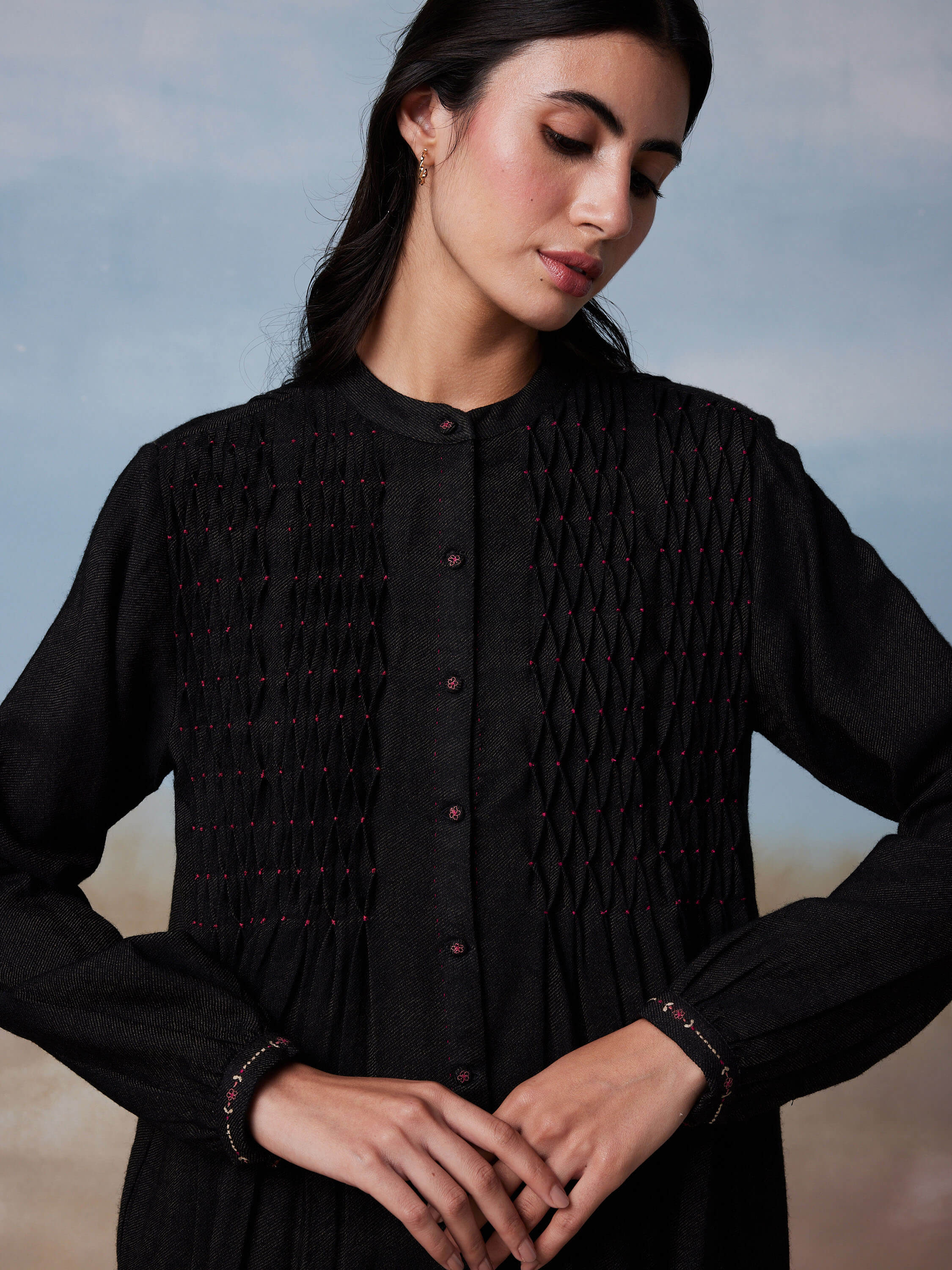 Elegant woman in black long-sleeved embroidered dress