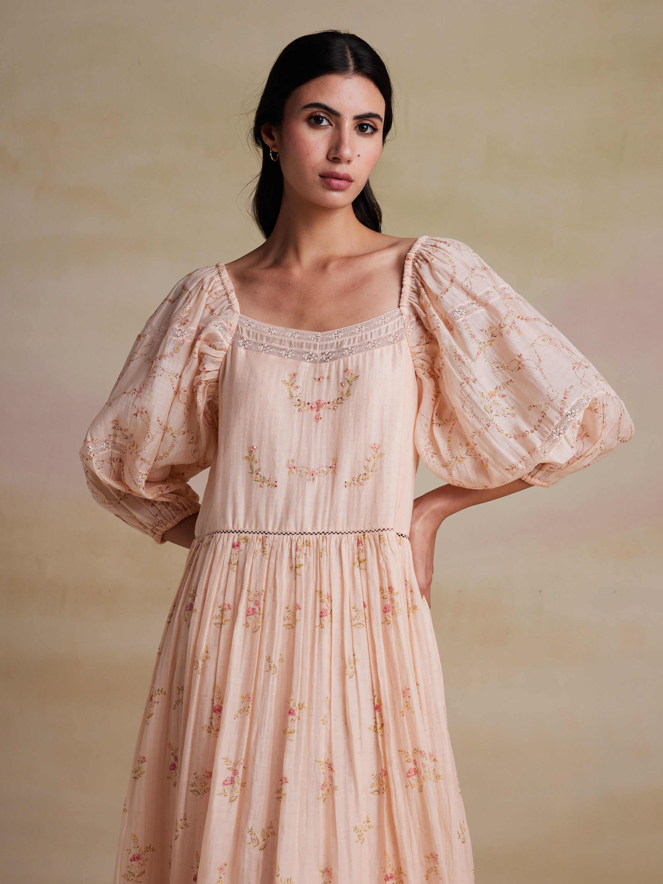 Woman wearing vintage floral dress with puff sleeves against neutral background.