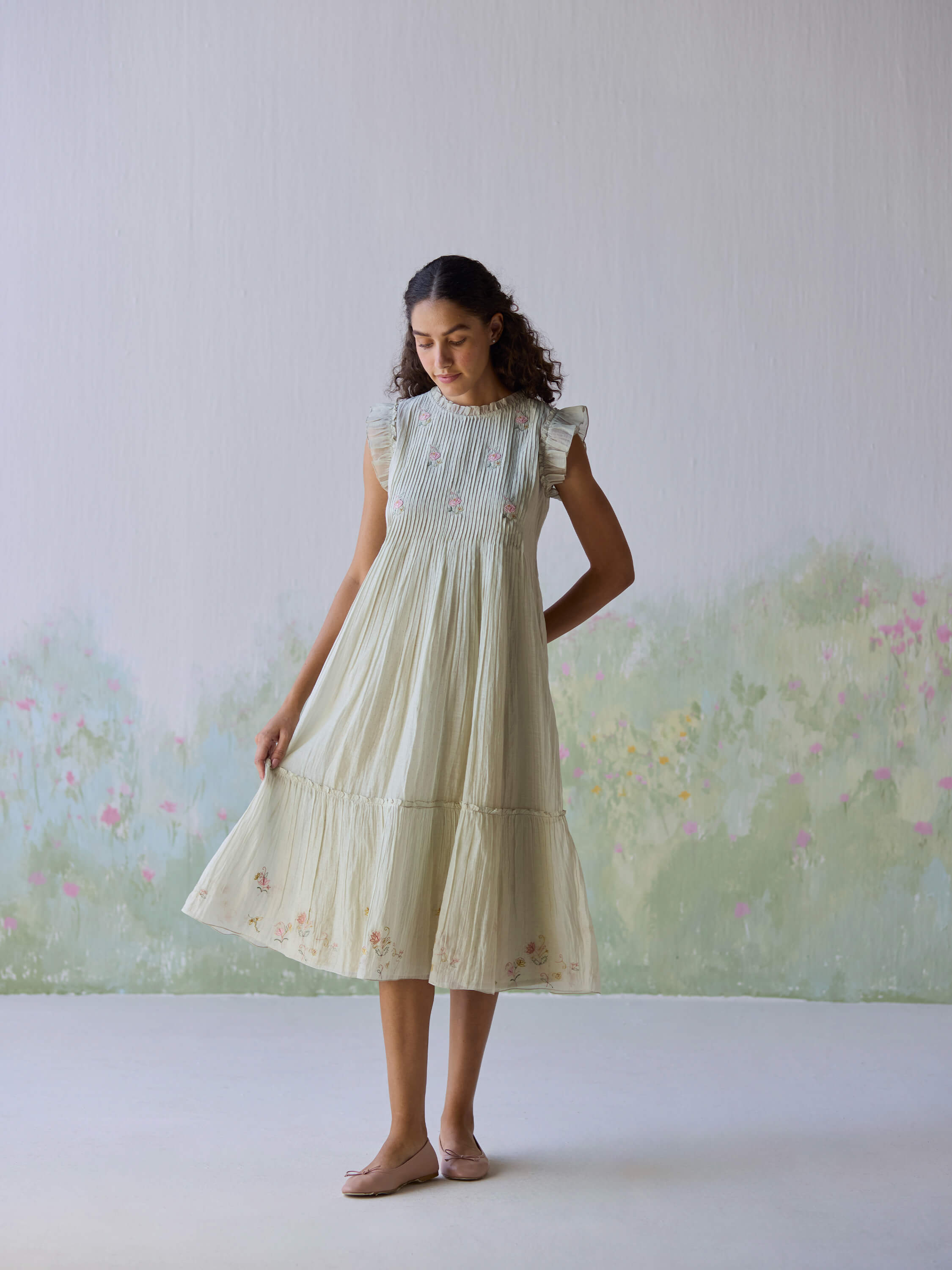 Model in Flutter Fields Midi Dress against floral background.