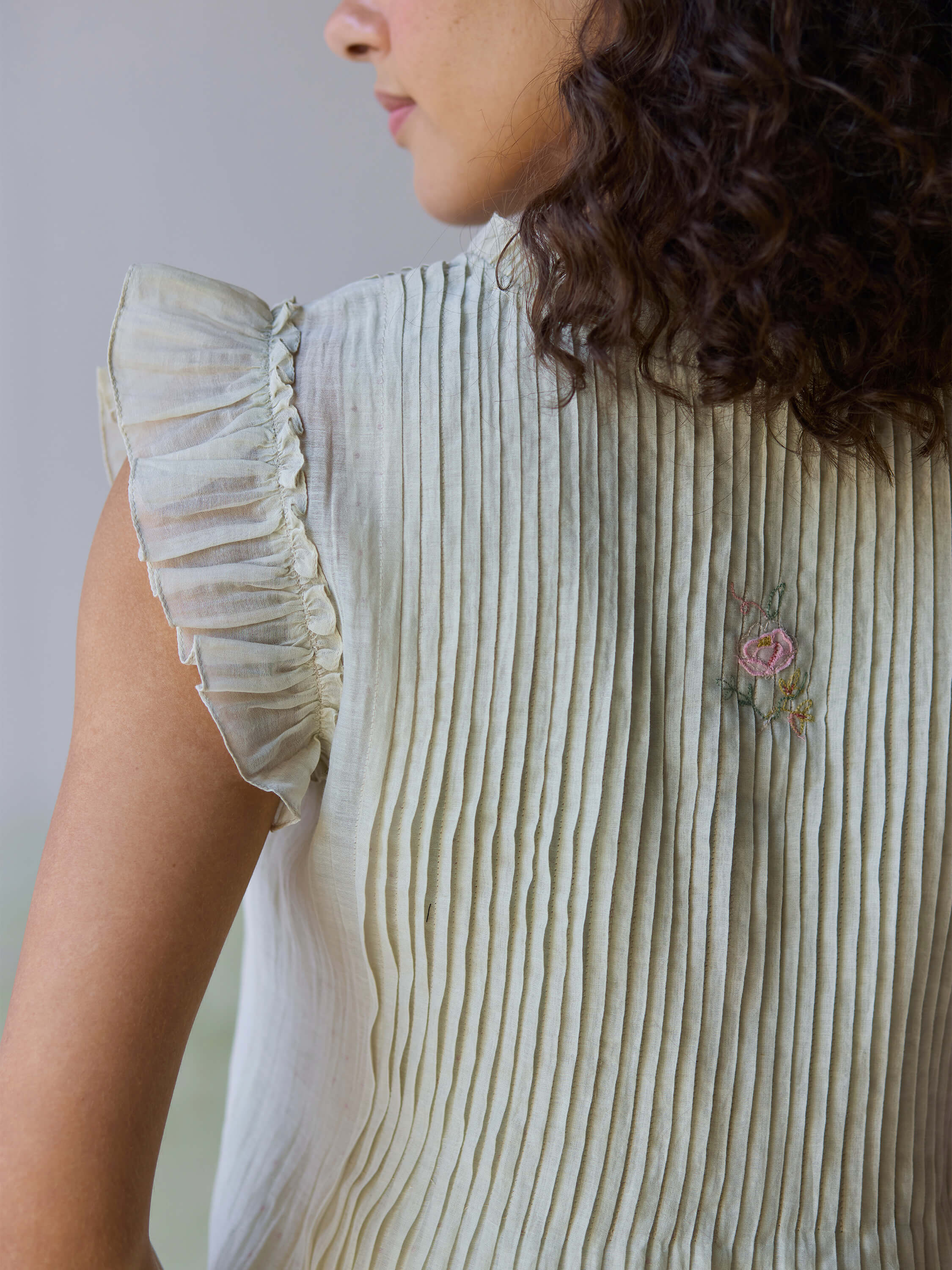 Flutter Fields Midi Dress showcasing delicate pleats and floral embroidery details.