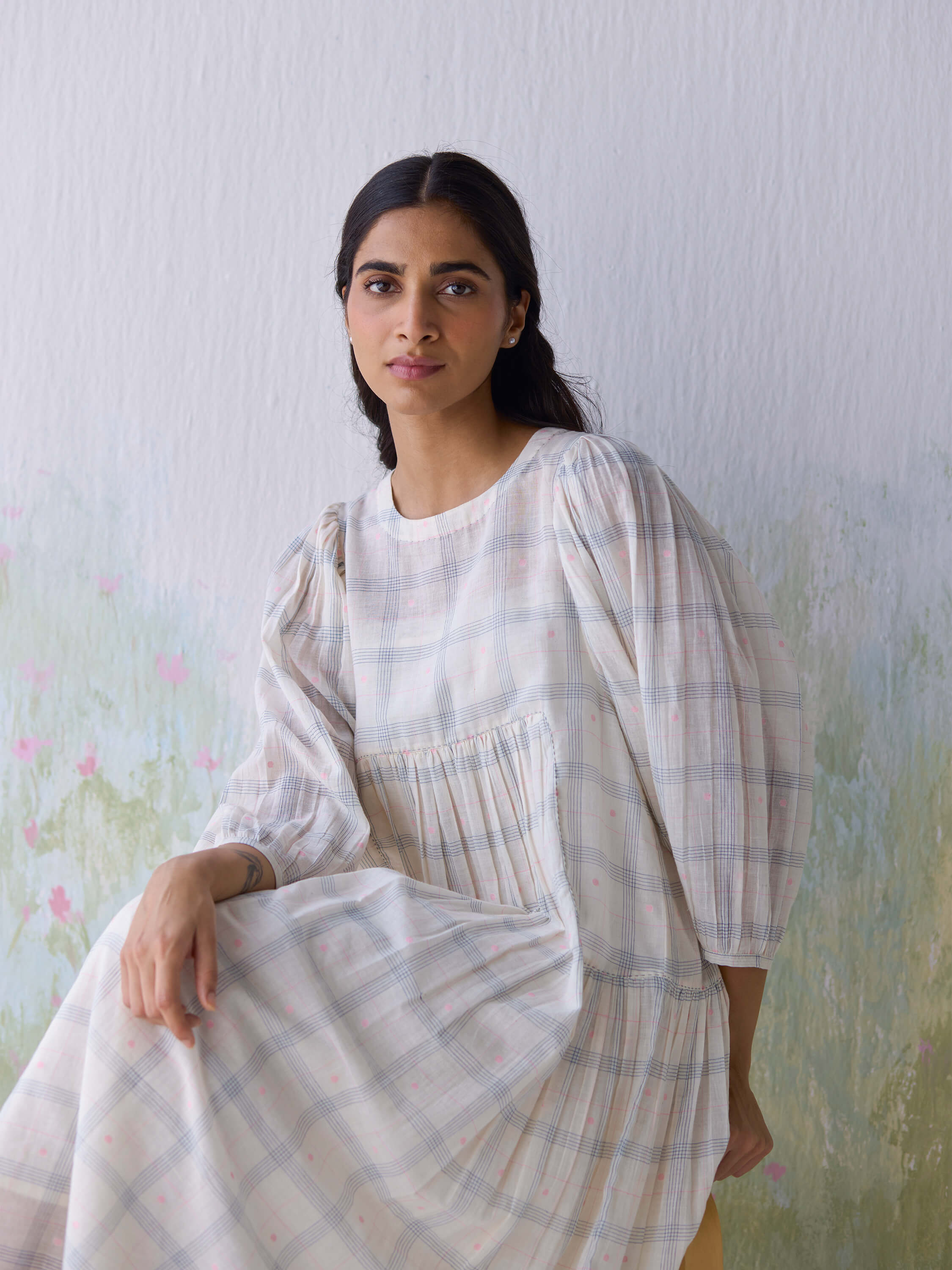 Gentle Days Jamdani Dress in soft plaid fabric, model sitting elegantly.