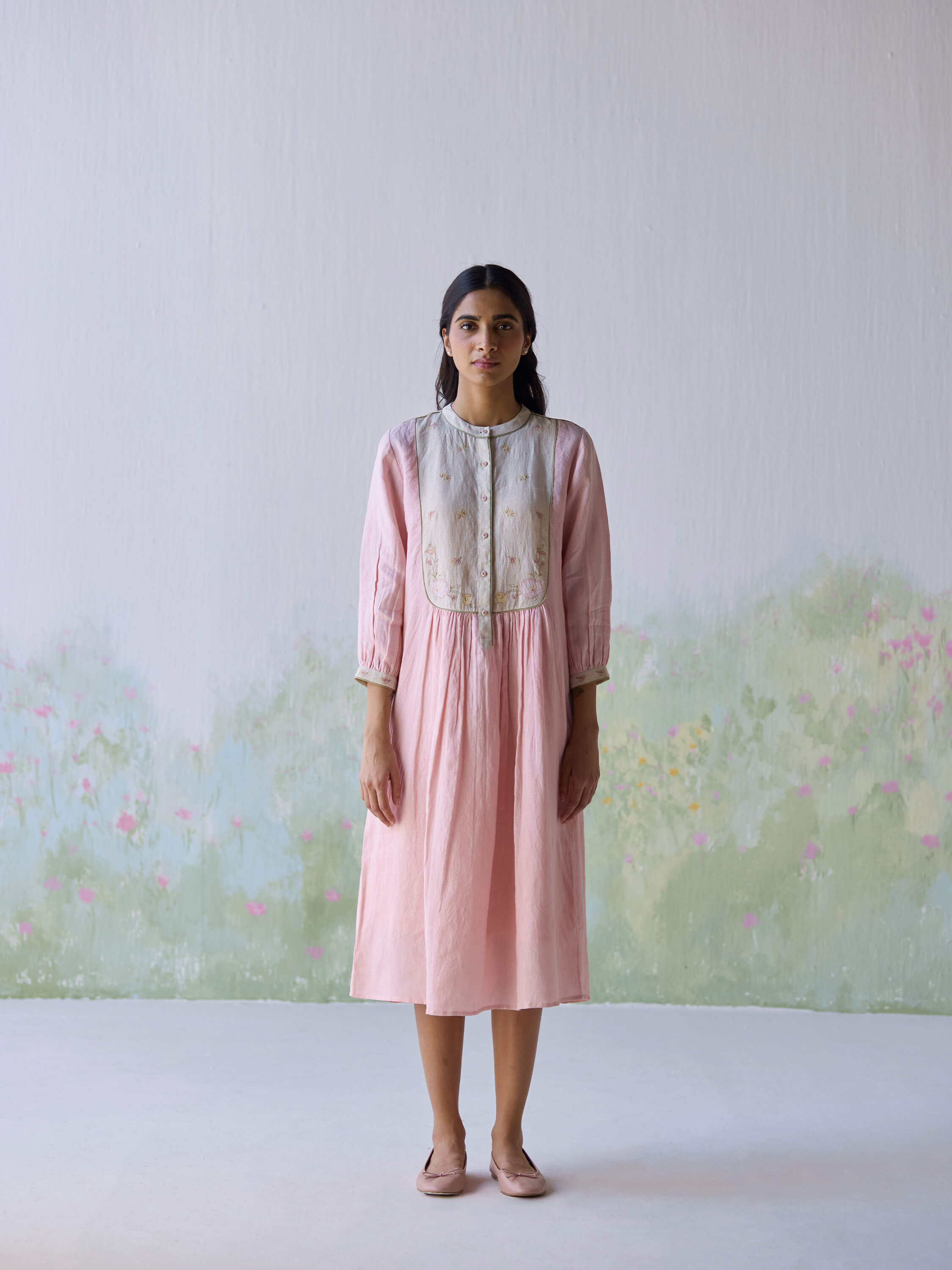 Elegant pink linen dress featured in serene floral background.