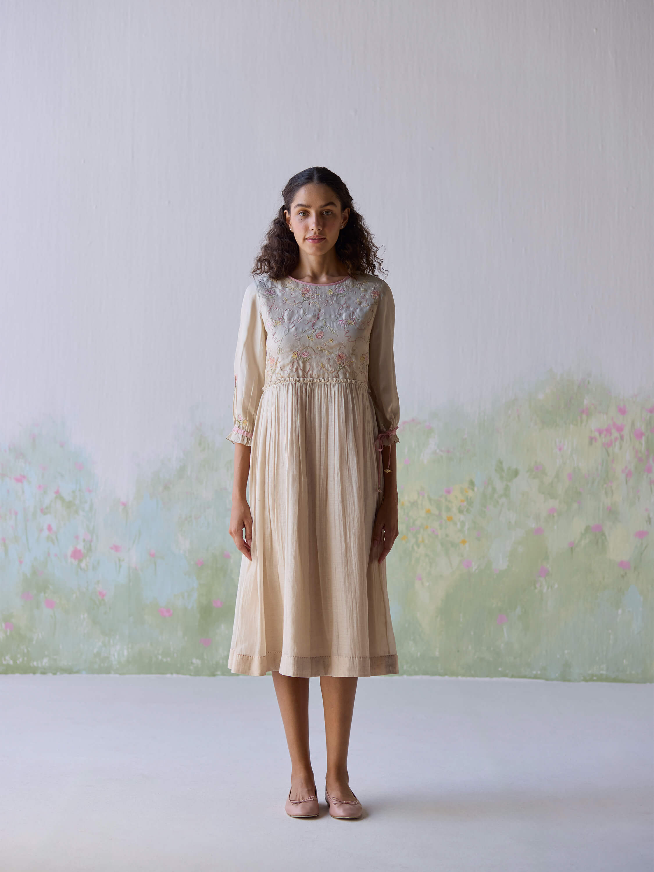 Sonata Embroidered Dress on model with floral background.