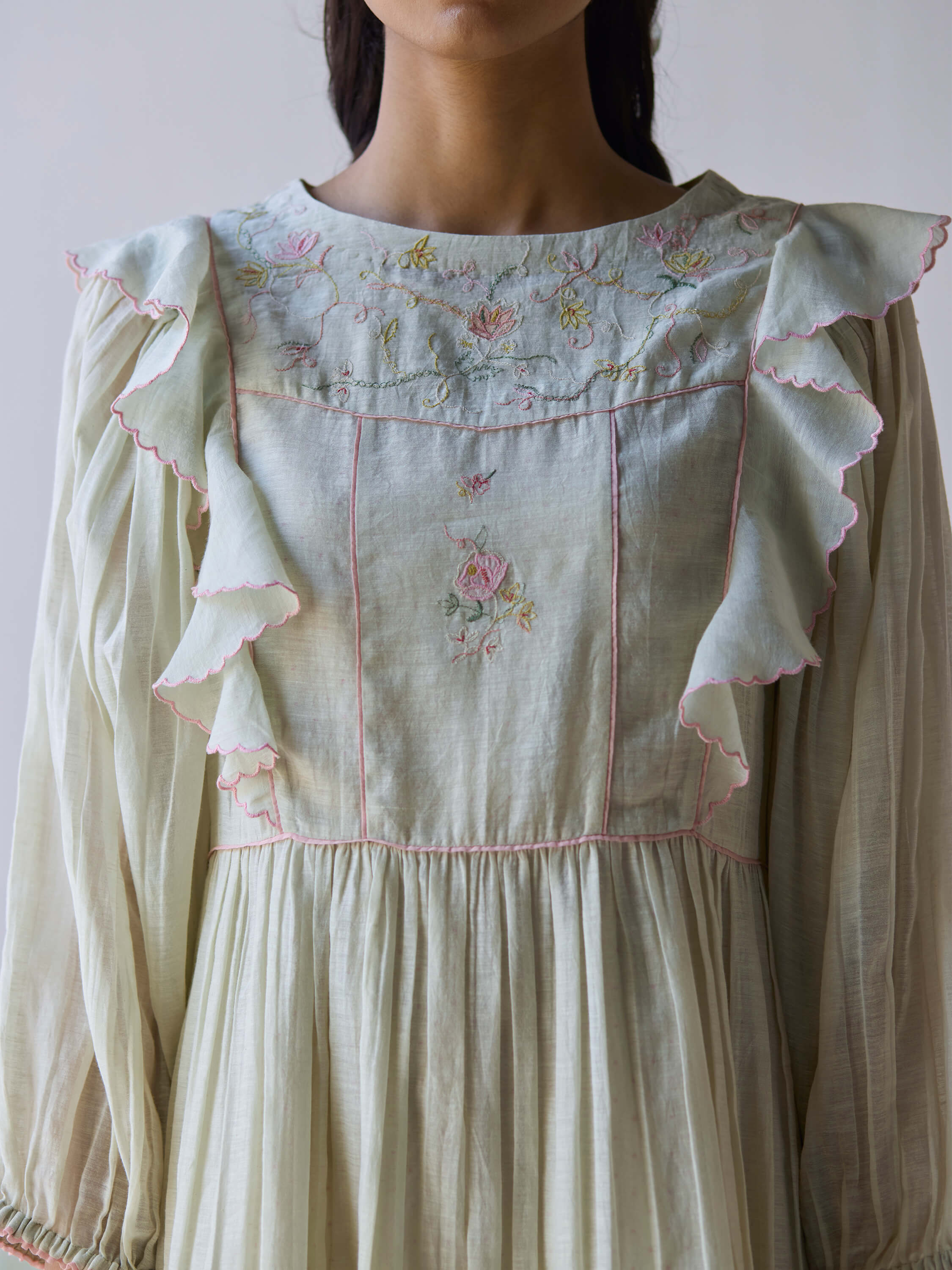 Light green midi dress with floral embroidery and ruffle details.