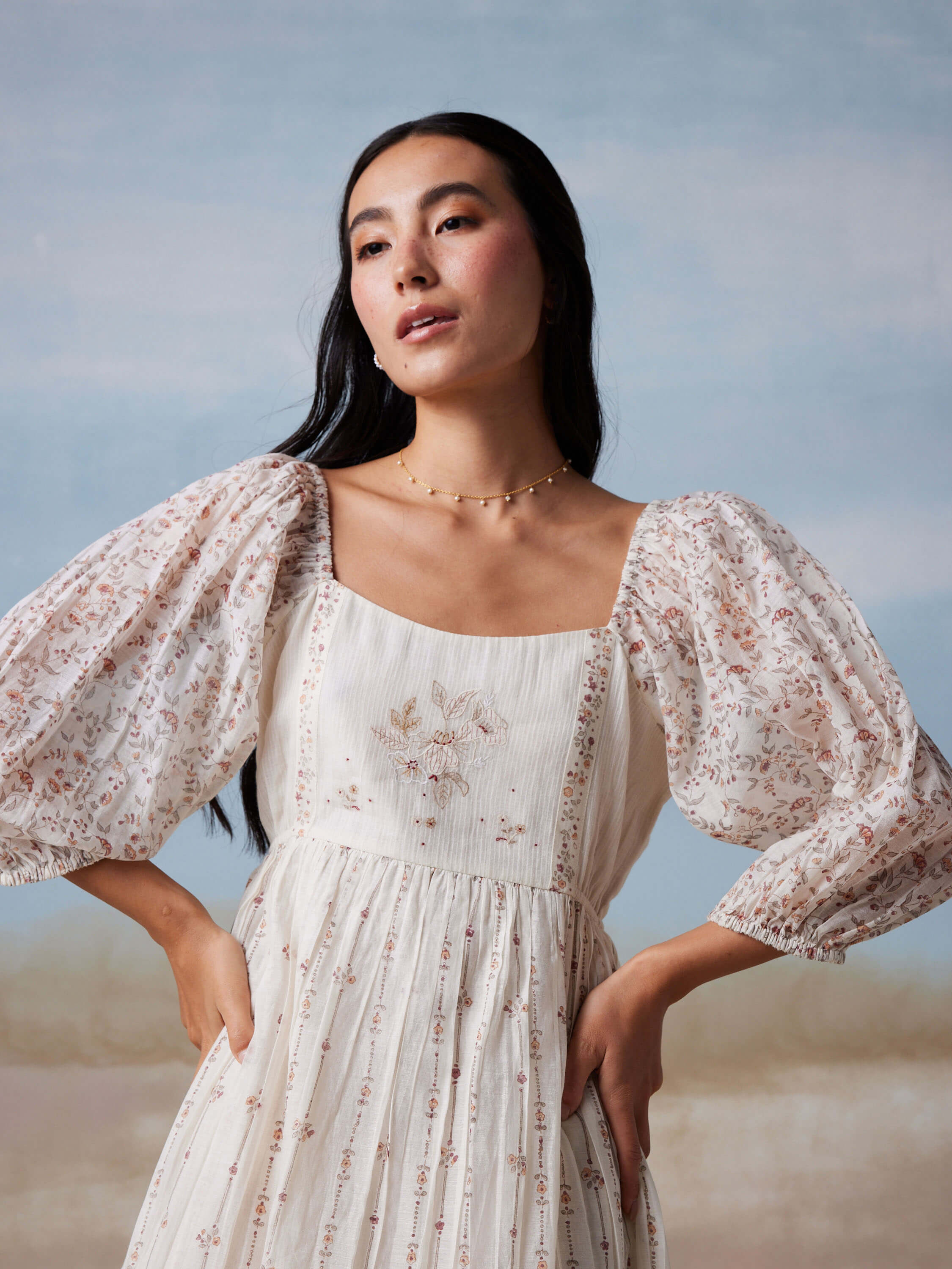 Woman in white floral dress with puff sleeves.