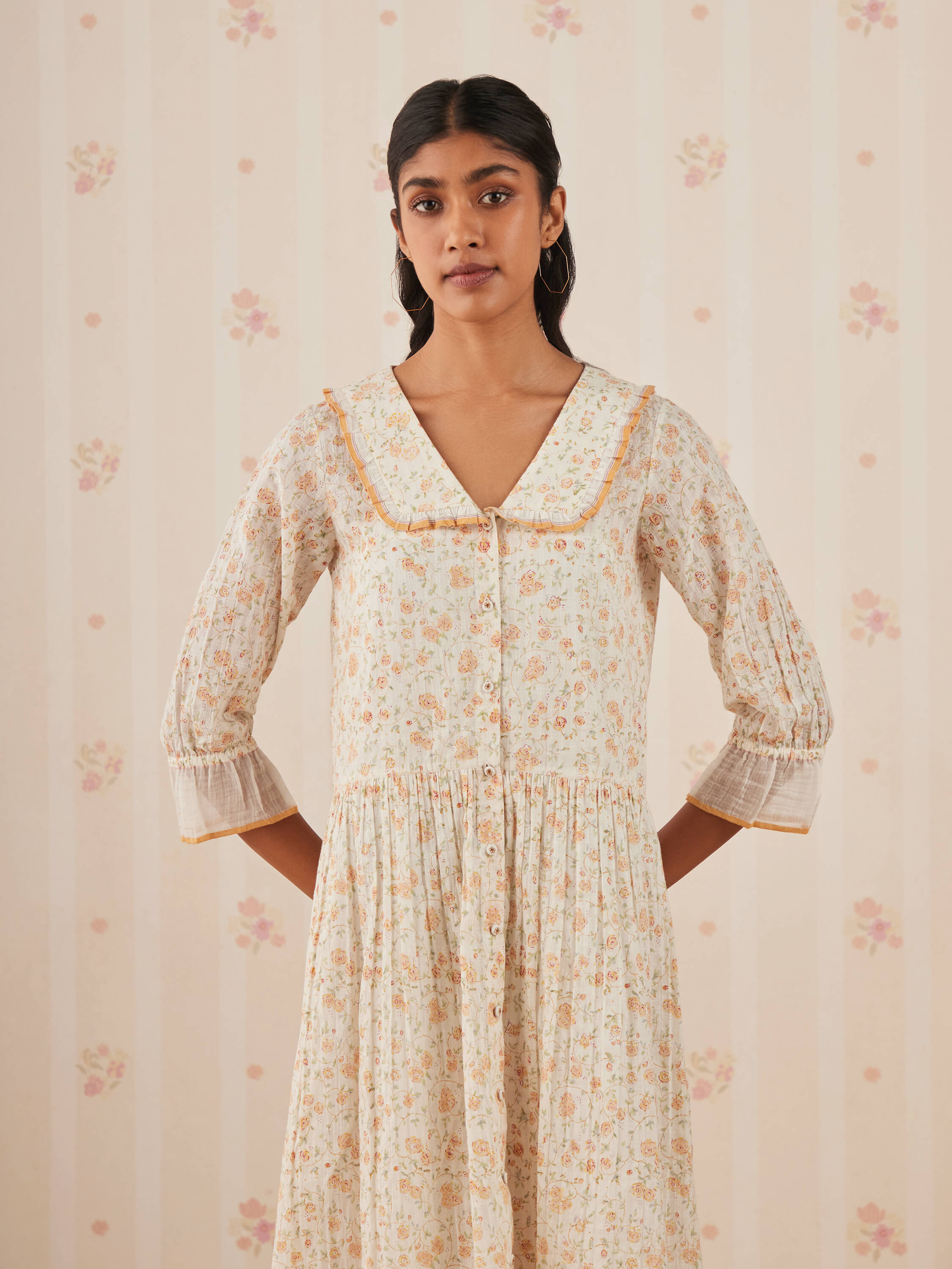 Woman wearing vintage floral dress with a Peter Pan collar.