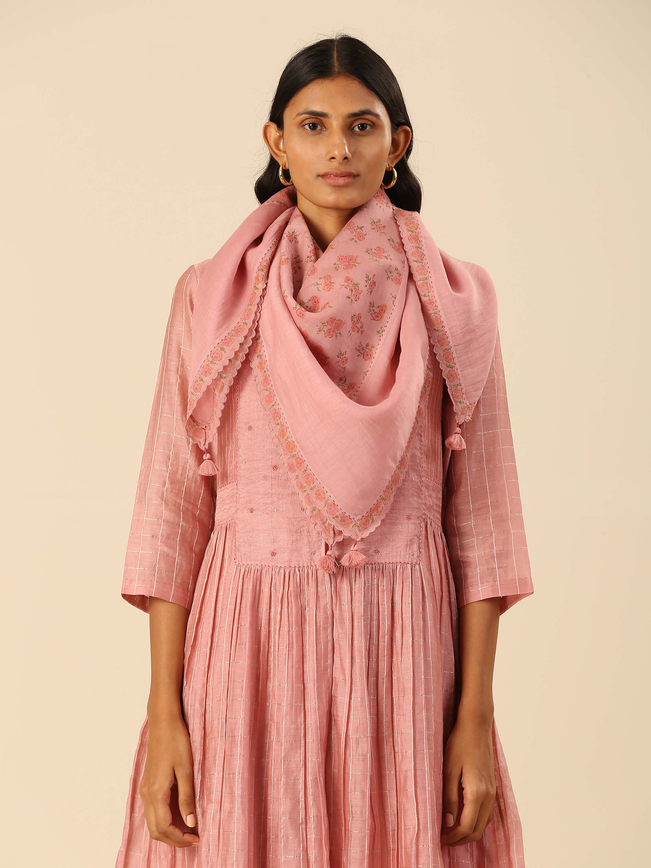 Woman in pink traditional dress and embroidered shawl looking forward.
