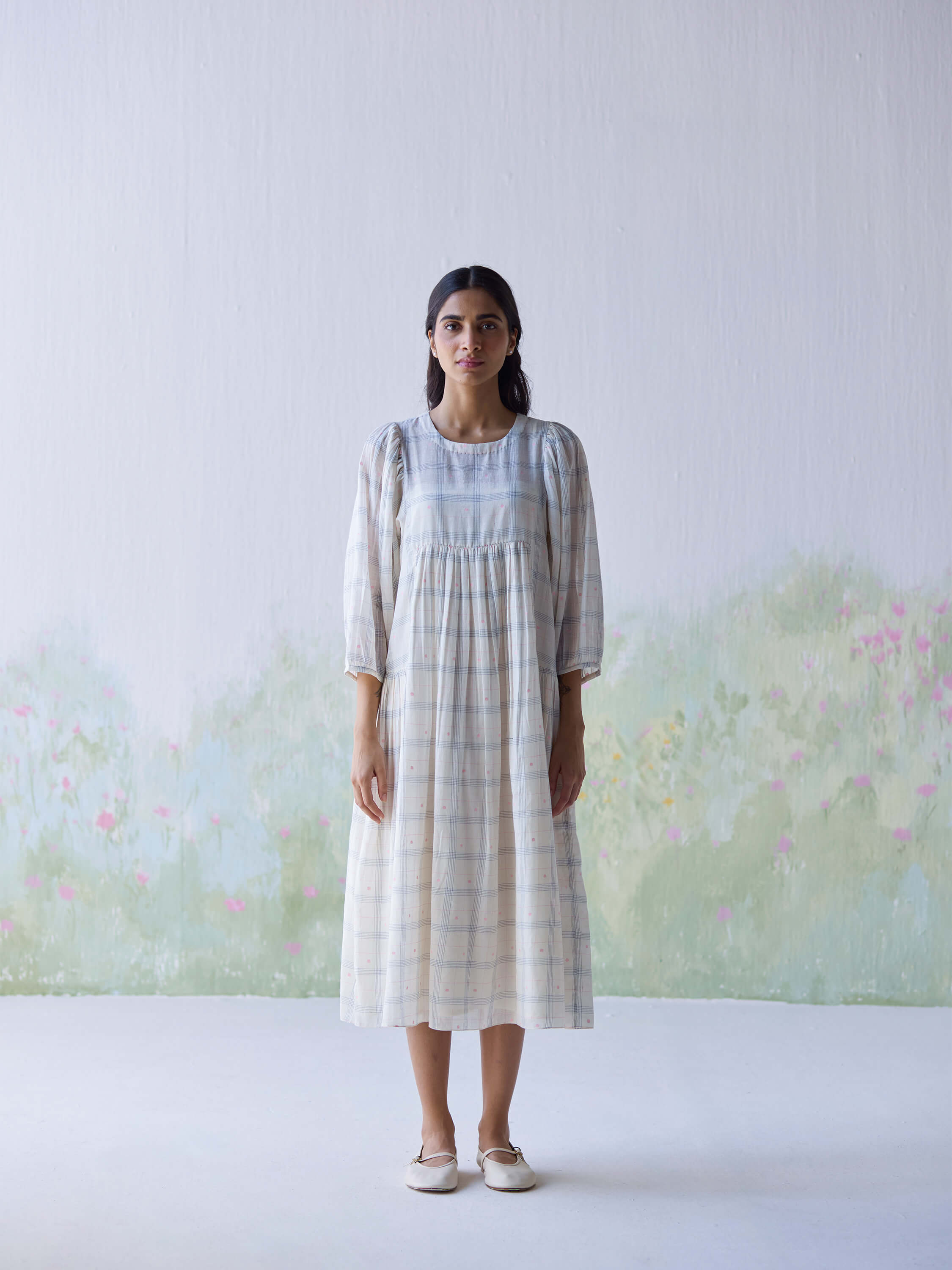 Gentle Days Jamdani Dress displayed on model against floral backdrop.