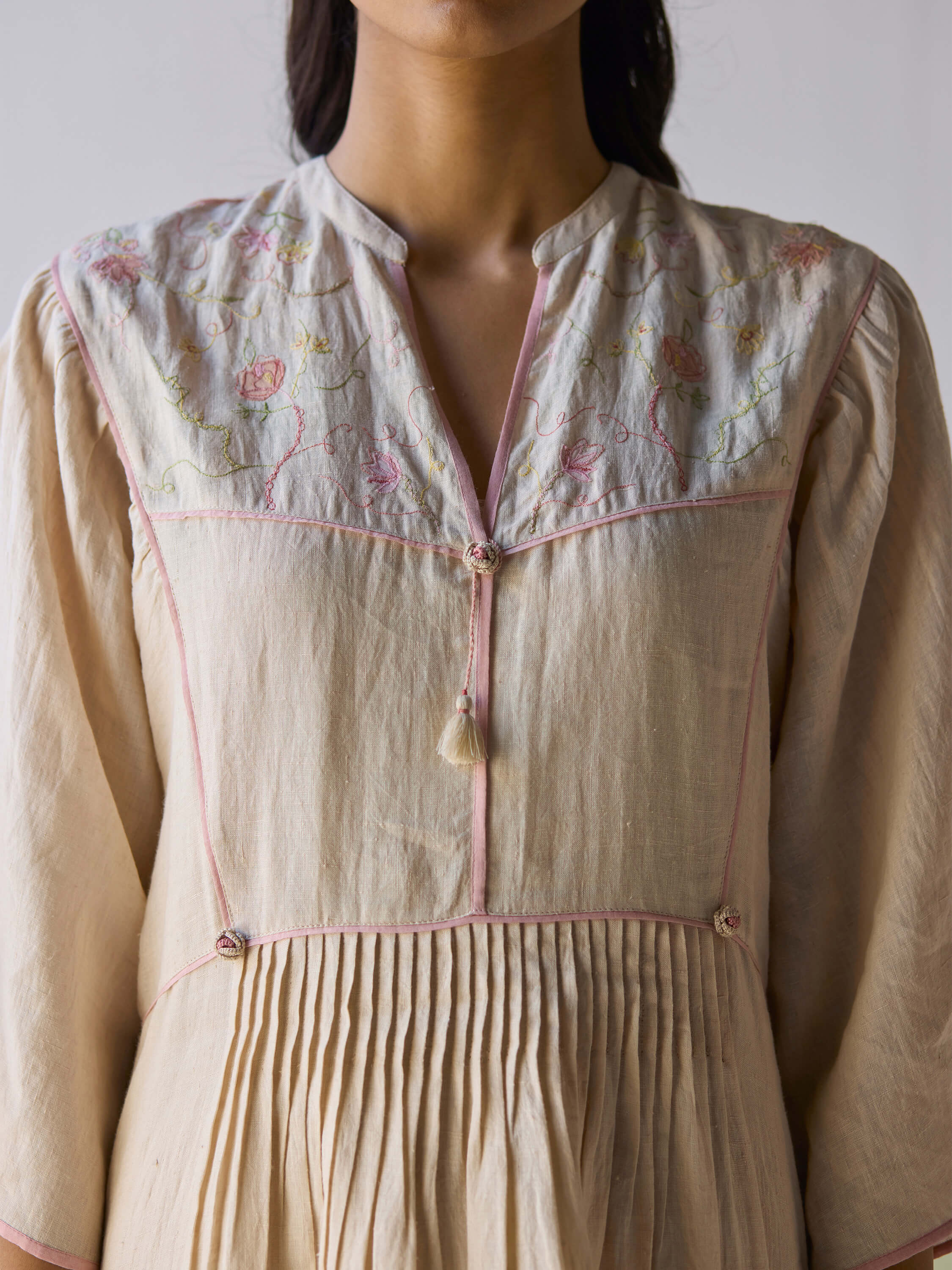Sweetly embroidered kaftan dress with floral design and pleated detailing.