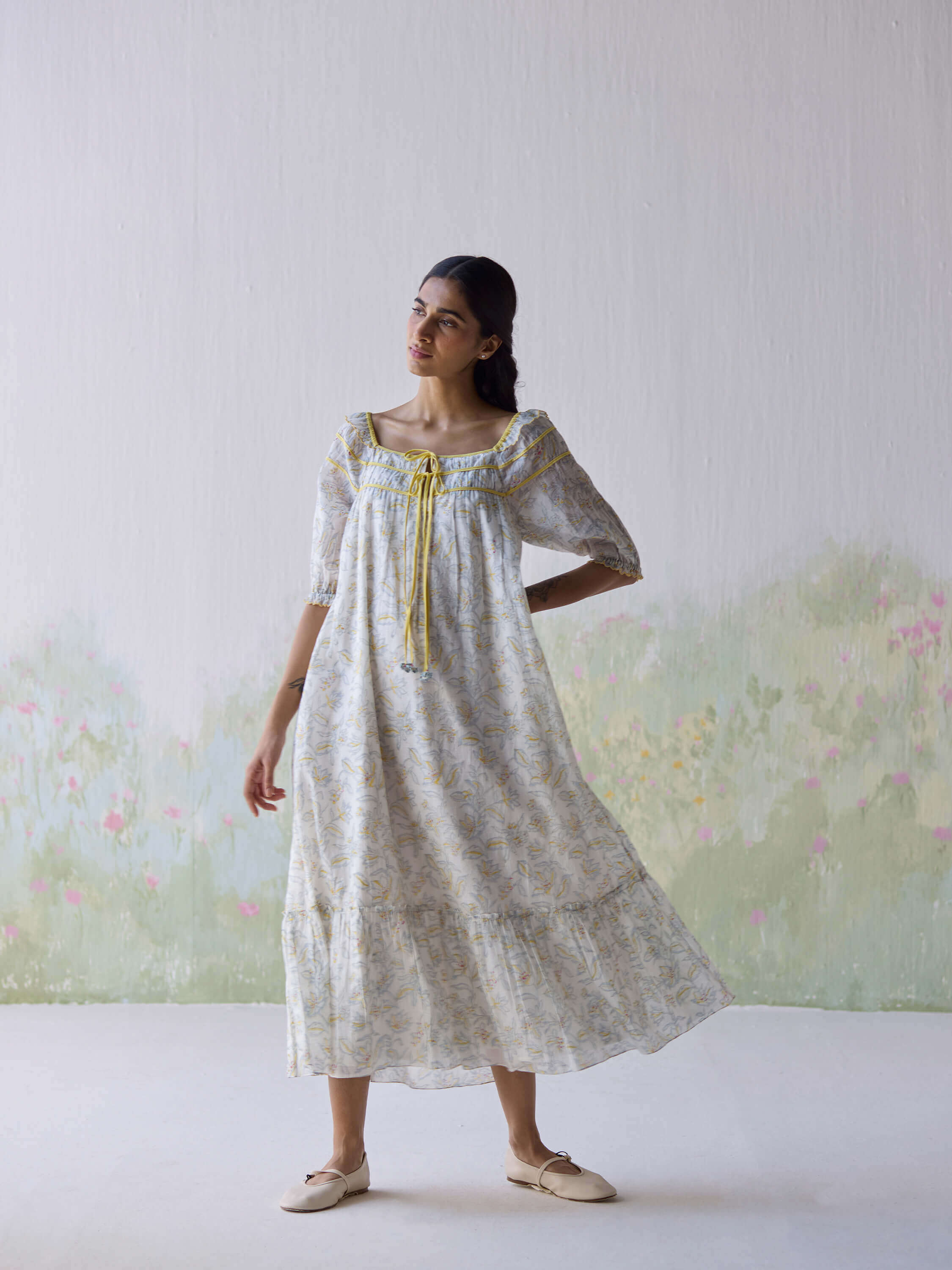 Woman wearing a floral dress with a light background.
