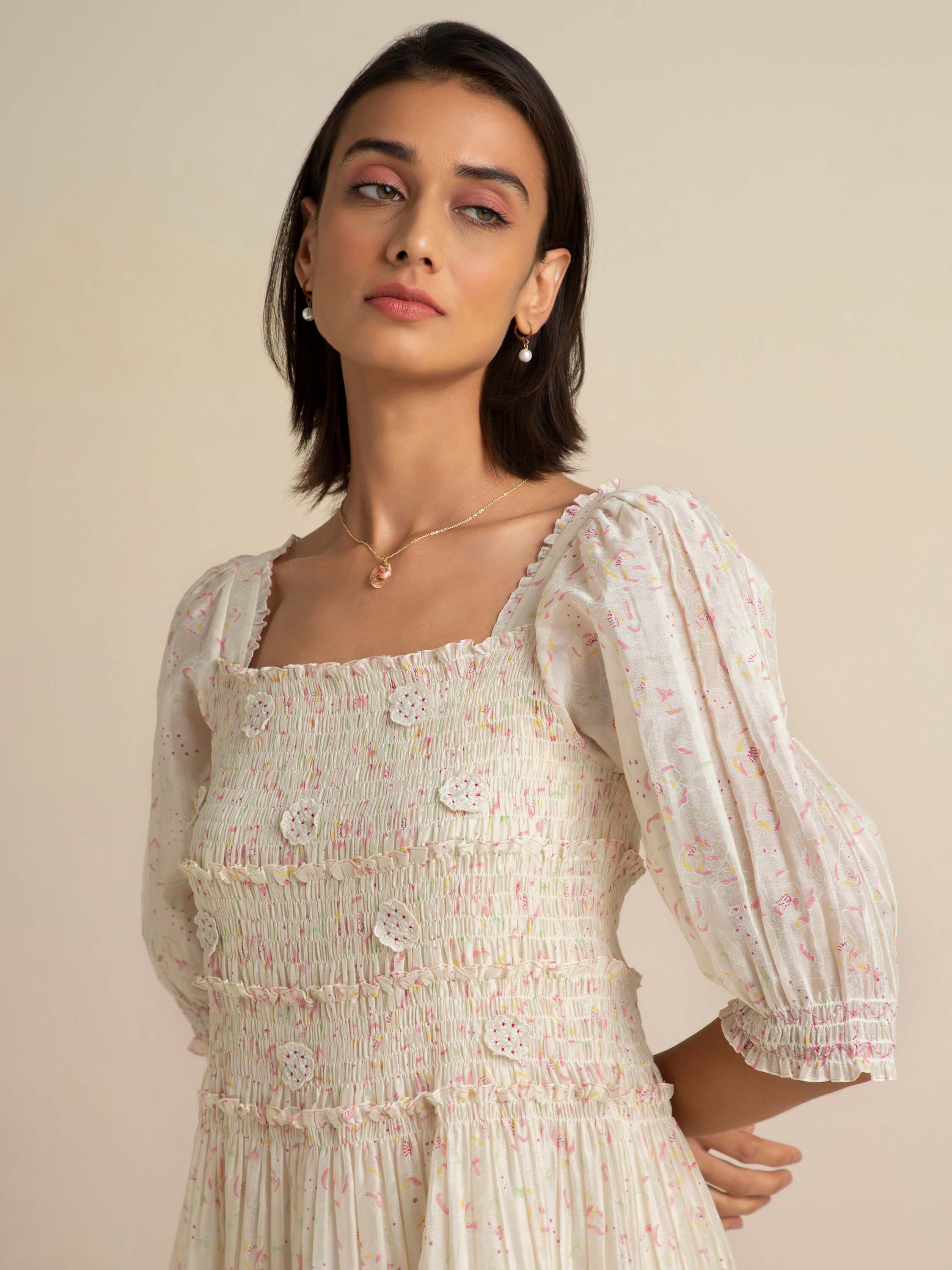 Woman in a floral smocked dress with puff sleeves.