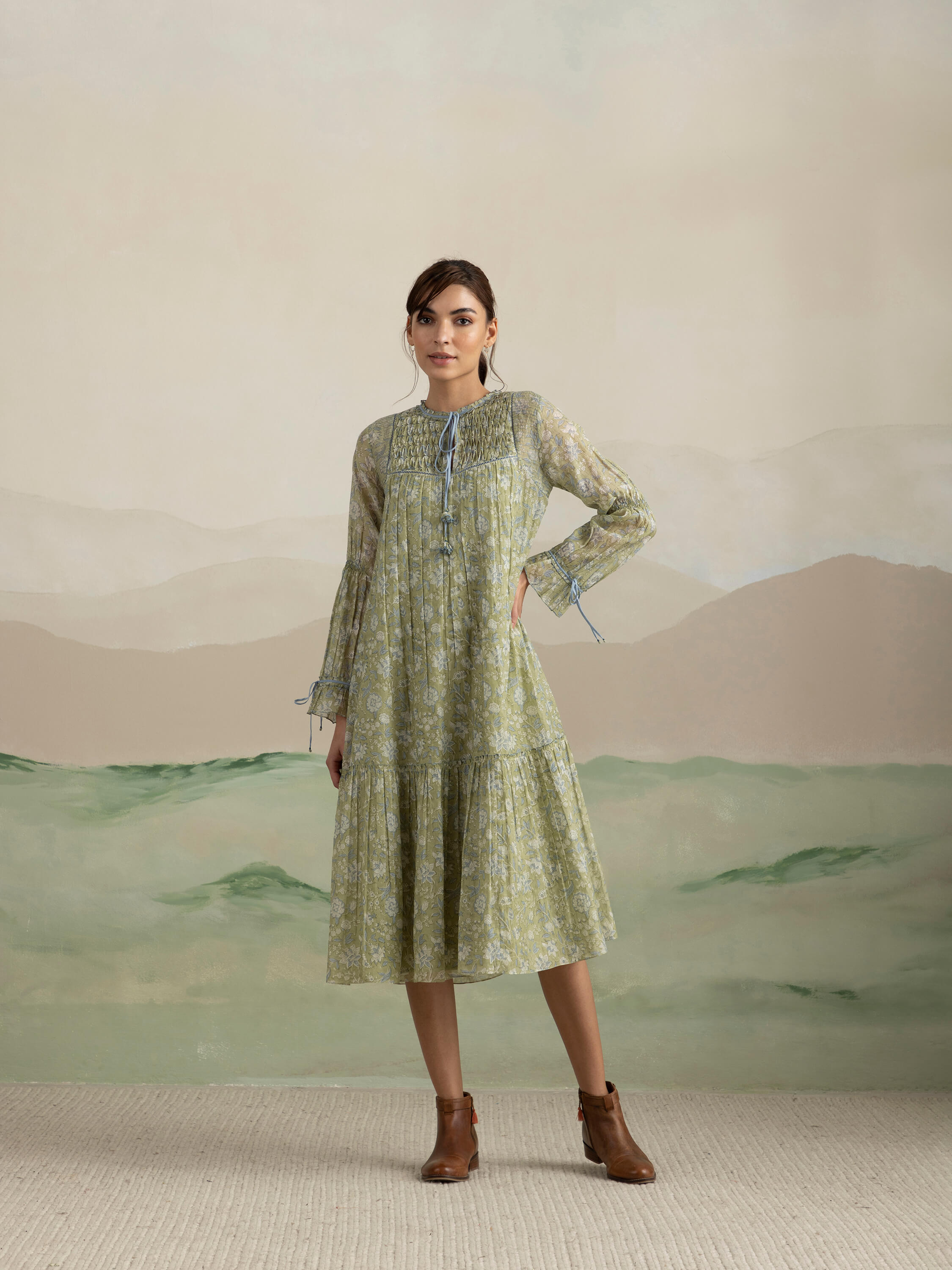 Woman in floral green dress with brown ankle boots.
