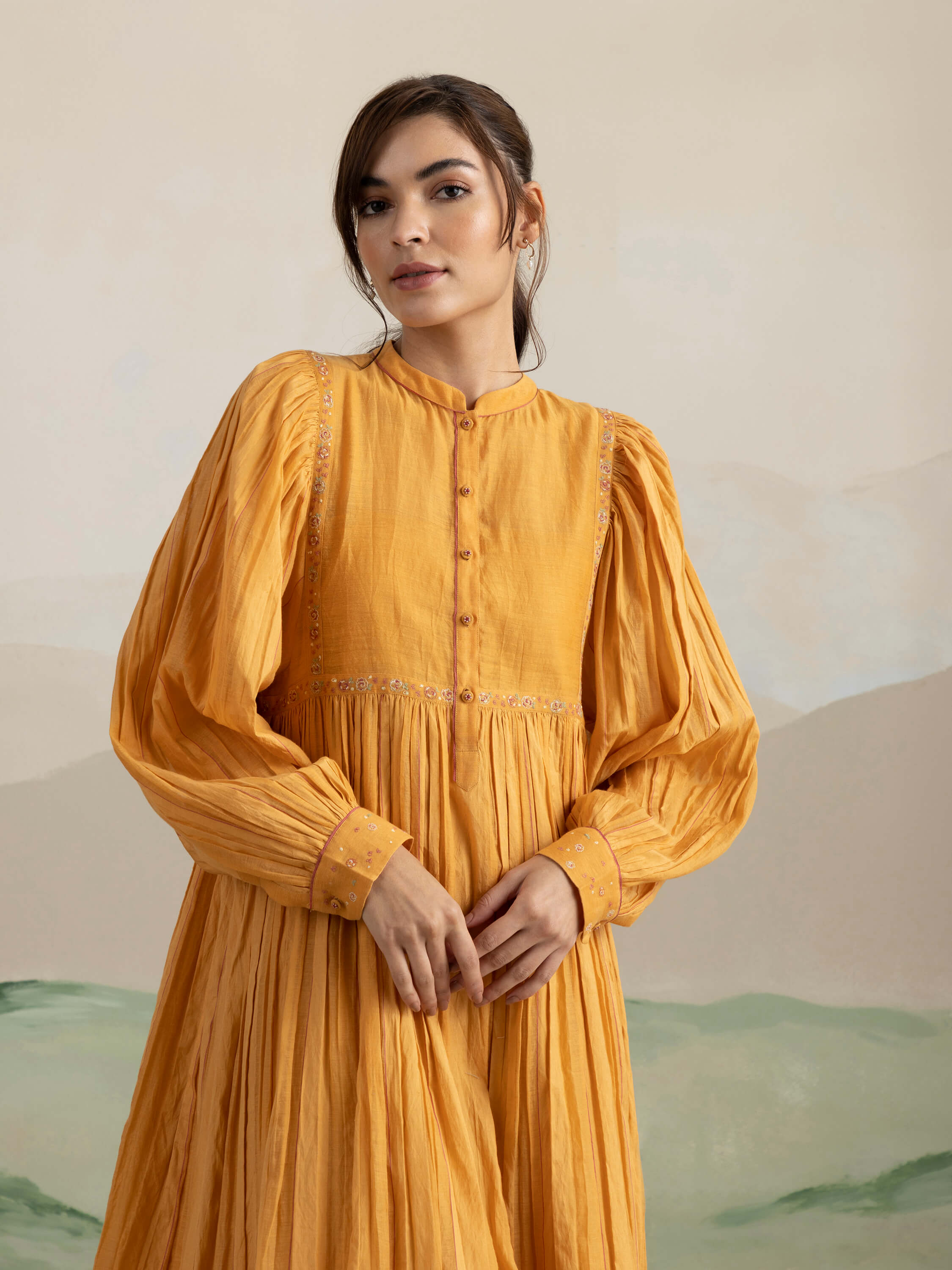 Young woman in mustard yellow long-sleeve dress.