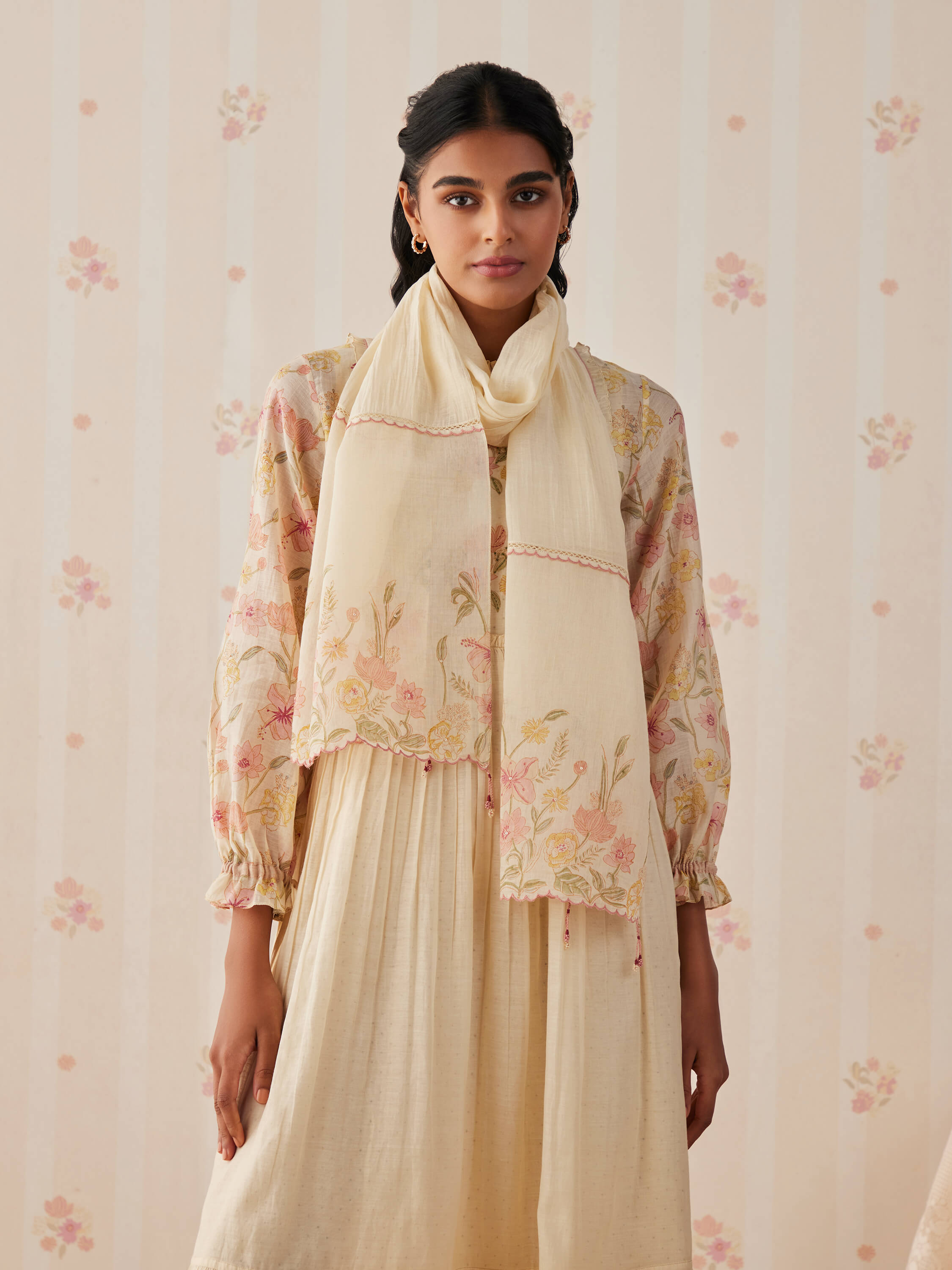 Woman in floral embroidered kurta with cream shawl.
