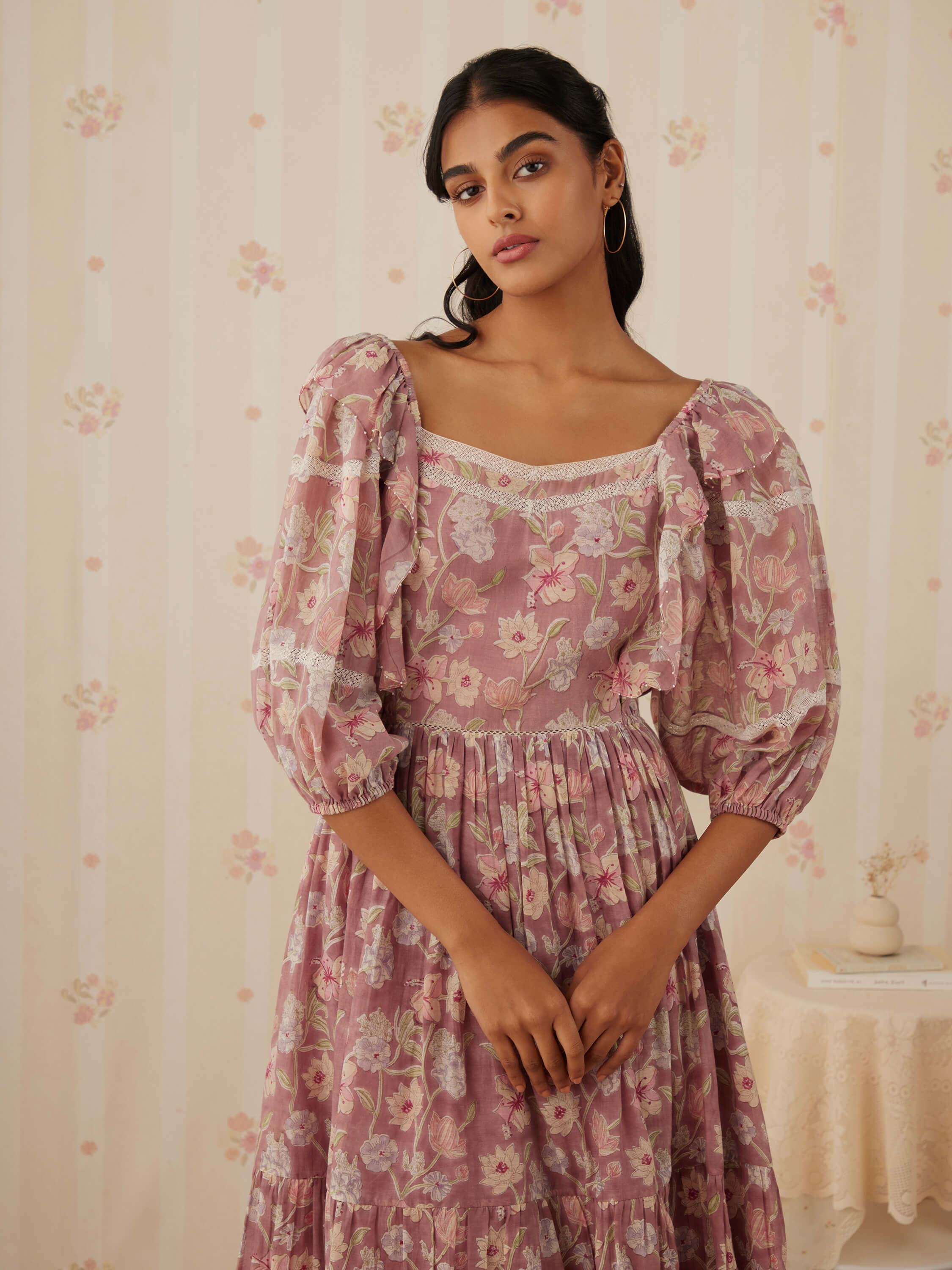 Woman in a floral patterned dress with puffed sleeves.